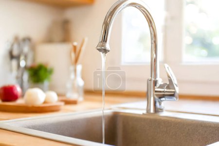 Téléchargez les photos : La rareté de l'eau : un robinet goutte à goutte. Un robinet de maison dégoulinant d'eau, symbolisant la question urgente de la pénurie d'eau - en image libre de droit