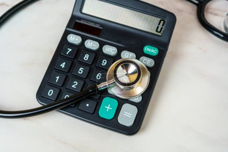 Stethoskop und Taschenrechner auf dem Tisch. Arztkosten, Gesundheitskosten, finanzielle Belastung durch Krankheit