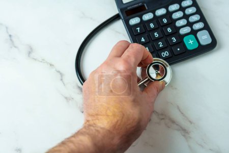 Finanzielle Gesundheitsprüfung. Stethoskop und Taschenrechner repräsentieren die finanzielle Gesundheit eines Unternehmens oder einer Einzelperson.