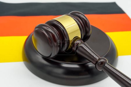 Rechtliche Autorität in Deutschland vertreten durch einen Hammer auf der deutschen Flagge.