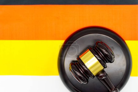 Rechtliche Autorität in Deutschland vertreten durch einen Hammer auf der deutschen Flagge.