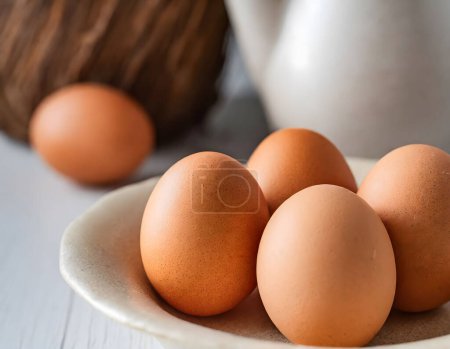 Una vista cercana de cinco huevos marrones en un plato. Simplicidad en la nutrición - huevos marrones frescos como símbolo de salubridad orgánica