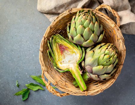 Photo for A basket of fresh green artichokes on a wooden board, portraying natural and healthy living - Royalty Free Image