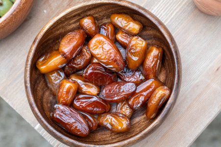 Fresh Dates in a Wooden Bowl in a Rustic Setting