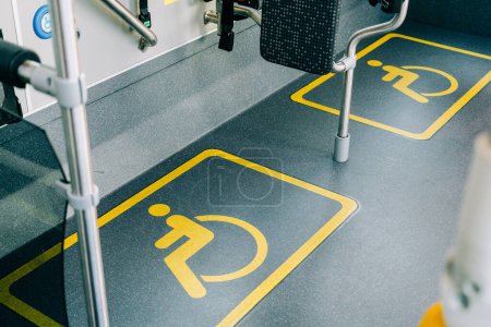 Un área claramente marcada y accesible dentro de un vehículo de transporte público reservado para pasajeros con discapacidad
