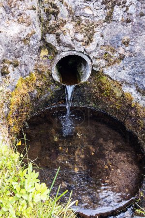 Téléchargez les photos : Pendant l'été, les eaux souterraines qui coulent du tuyau de béton dans l'environnement pendant la journée - en image libre de droit