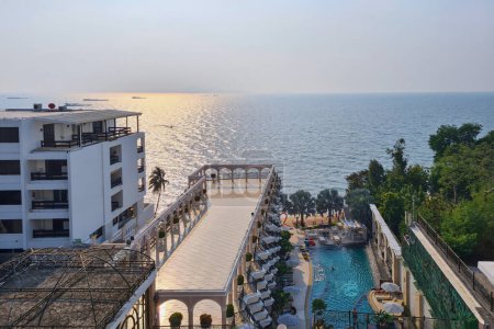 A hotel with a stunning view of the vast blue ocean that stretches below. The architecture of the hotel is visible from above, the outdoor recreation areas and swimming pools are visible.