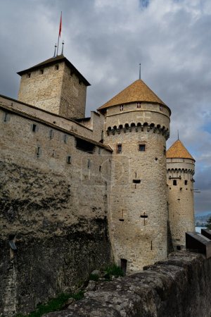 Téléchargez les photos : Les anciennes tourelles du Château de Chillon s'opposent au ciel orageux - en image libre de droit
