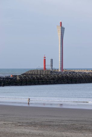 Foto de View of the futuristic looking Radar tower at the entrance to Ostend harbour in West Flanders, Belgium. Alternative minimalist beach scene with muted color and copyspace below. - Imagen libre de derechos