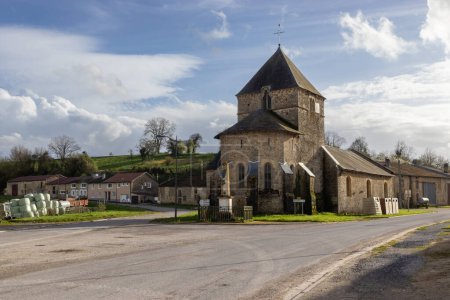 Vue sur le pittoresque hameau de Barricourt et sa vieille église, près de Tailly dans les Ardennes françaises, en Grand-Est en France, par une soirée de printemps ensoleillée.