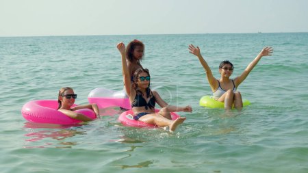 Foto de Un grupo de adolescentes corren y juegan en la playa para sus vacaciones de verano y sonríen y disfrutan de sus vacaciones. - Imagen libre de derechos