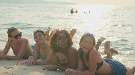 Téléchargez les photos : Un groupe d'adolescentes courir et jouer à la plage pour leurs vacances d'été et ils sourient et profiter de leurs vacances. - en image libre de droit