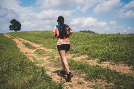 Téléchargez les photos : Young women active trail runners the top of a mountain in the afternoon, ultra marathon runners adventuring outdoors - en image libre de droit