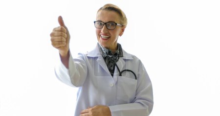 Foto de Mujer médico con estetoscopio en uniforme y pulgares hacia arriba sobre el fondo con espacio de copia, concepto médico - Imagen libre de derechos