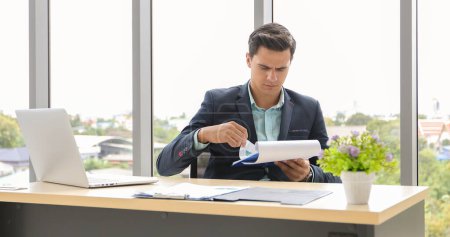 Téléchargez les photos : Homme d'affaires utilisant un ordinateur portable et contemplant tout en travaillant à son bureau dans le bureau. - en image libre de droit