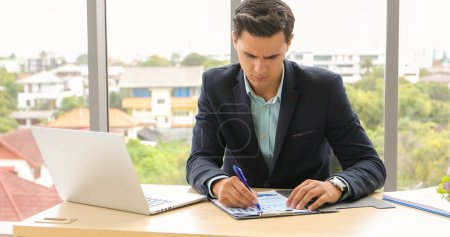 Photo for Businessman using laptop and contemplating while working at his desk in the office. - Royalty Free Image