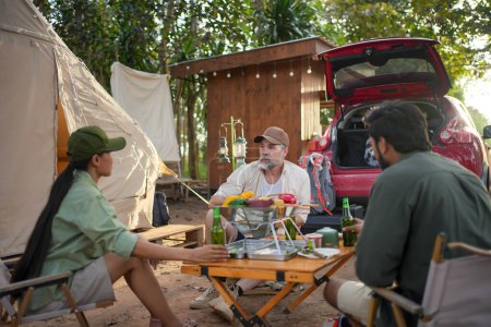 Foto de Group tourists drinking beer-alcohol and play guitar together with enjoy and happiness in Summer while camping - Imagen libre de derechos