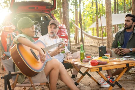 Téléchargez les photos : Group tourists drinking beer-alcohol and play guitar together with enjoy and happiness in Summer while camping - en image libre de droit