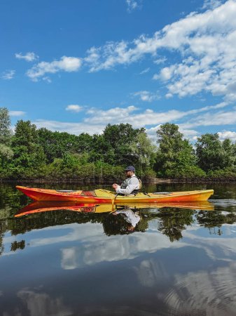 Téléchargez les photos : Jeune homme caucasien kayak sur la rivière calme - en image libre de droit