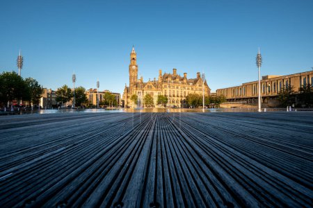 Photo for Around the fountain is a wooden deck and a benches for tourists in Bradford Town Hall - Royalty Free Image