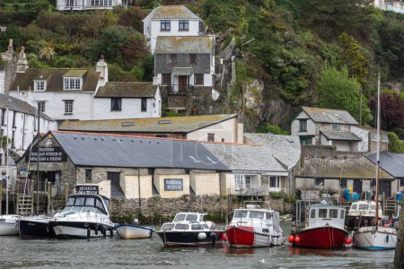 Téléchargez les photos : Port de Polpero avec des bateaux amarrés, chalets blancs accrochés aux falaises boisées en Cornouailles Royaume-Uni - en image libre de droit