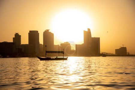 Téléchargez les photos : Architecture de Dubaï avec coucher de soleil et bateau dans l'eau de mer - en image libre de droit