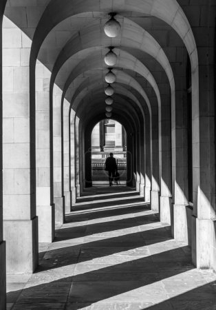 Photo for Man walking in arched walkway in Manchester Town hall - Royalty Free Image