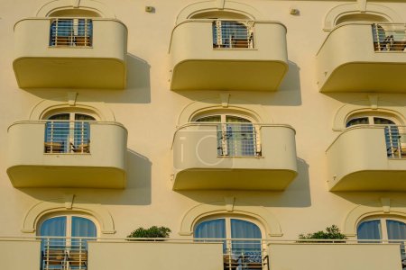 Foto de Senigallia, Italia: Fachada amarilla del edificio moderno con líneas de balcones con ventanas - Imagen libre de derechos