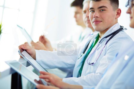 Photo for Medical team sitting and discussing at table. - Royalty Free Image