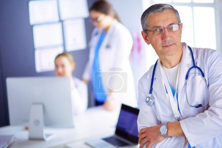 Photo for Portrait of a smiling doctor in his bright office. - Royalty Free Image