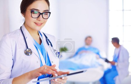 Photo for Female doctor using tablet computer in hospital lobby, - Royalty Free Image