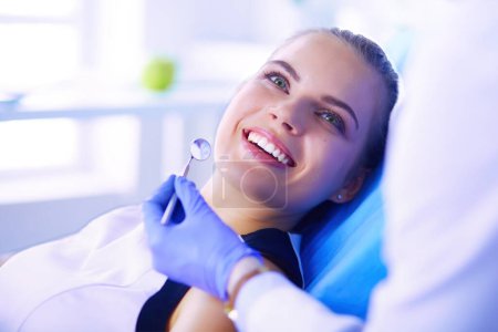 Photo for Young Female patient with pretty smile examining dental inspection at dentist office - Royalty Free Image