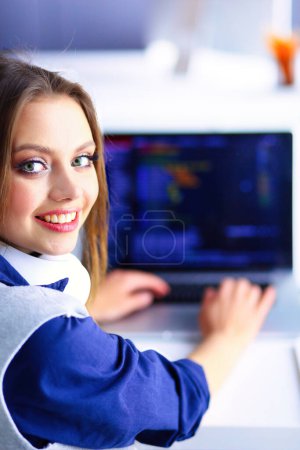 Foto de Joven empresaria confiada trabajando en el escritorio de la oficina y escribiendo con una computadora portátil. - Imagen libre de derechos