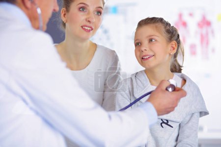 Téléchargez les photos : Fille et médecin avec stéthoscope à l'écoute des battements de coeur. - en image libre de droit