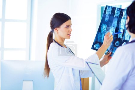 Foto de Dos doctores discutiendo problemas médicos y revisando radiografías en un hospital - Imagen libre de derechos