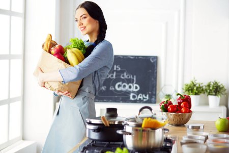 Téléchargez les photos : Jeune femme tenant sac d'épicerie avec des légumes. - en image libre de droit