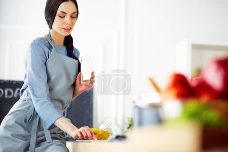 Foto de Mujer hornear en casa siguiendo la receta en una tableta. - Imagen libre de derechos