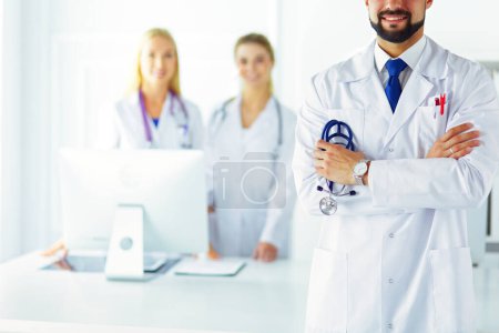 Photo for Young male doctor in front of medical group. - Royalty Free Image