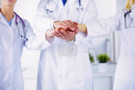 Téléchargez les photos : Médecins et infirmières dans une équipe médicale empilant les mains. - en image libre de droit