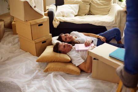 Photo for High view of happy couple lying on floor with a lot of boxes. - Royalty Free Image