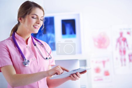Foto de Mujer doctora revisando los datos médicos en la tableta PC. - Imagen libre de derechos
