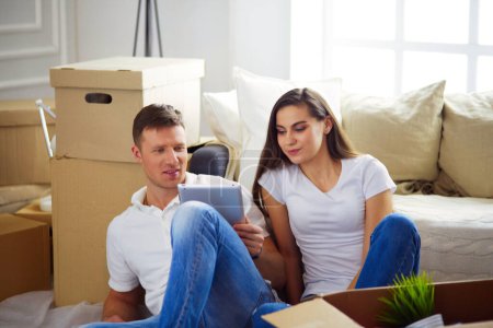 Téléchargez les photos : Joyeux couple planification décoration lors du déménagement assis sur le sol
. - en image libre de droit