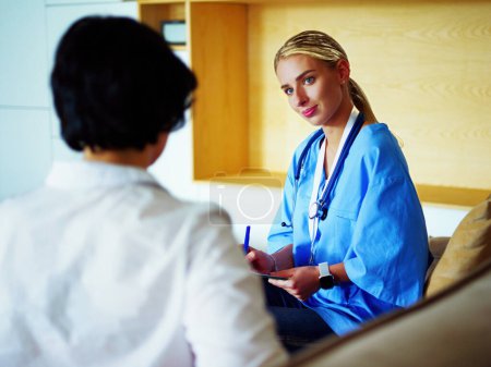 Photo for Female doctor talking to patient sitting in medical office. - Royalty Free Image
