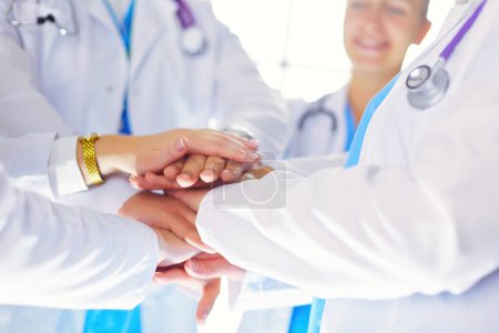 Photo for Doctors and nurses in a medical team stacking hands. - Royalty Free Image