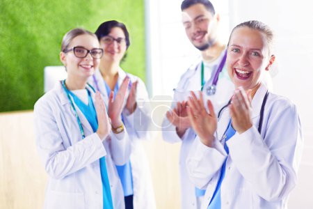 Téléchargez les photos : Bonne équipe médicale composée de médecins masculins et féminins souriant largement et donnant un pouce de succès et d'espoir. - en image libre de droit