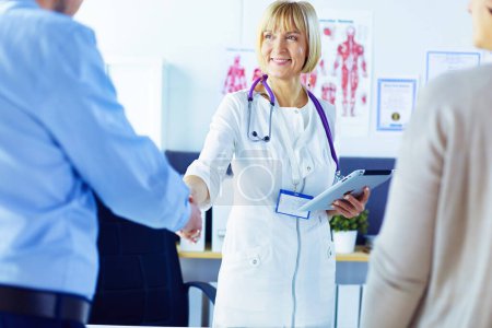 Photo for Woman doctor handshaking with a senior couple. - Royalty Free Image