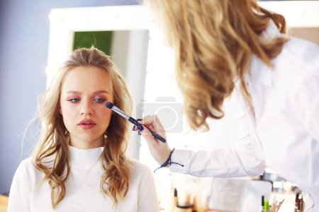 Téléchargez les photos : Maquilleuse faisant maquillage pour jeune belle mariée appliquant maquillage de mariage. - en image libre de droit