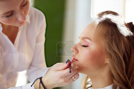 Photo for Make up artist doing professional make up of young woman. - Royalty Free Image