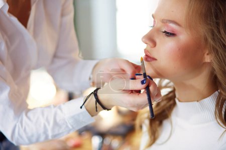 Téléchargez les photos : Maquilleuse faisant du maquillage professionnel de jeune femme. - en image libre de droit