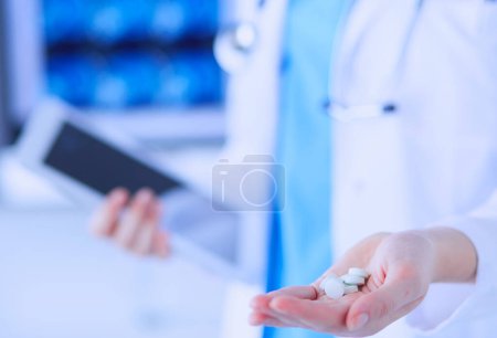 Foto de Primer plano de las manos de los médicos sosteniendo pastillas y tabletas en la clínica - Imagen libre de derechos
